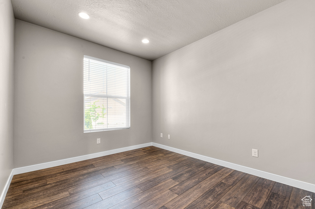 Unfurnished room with dark wood-style floors, a textured ceiling, and recessed lighting