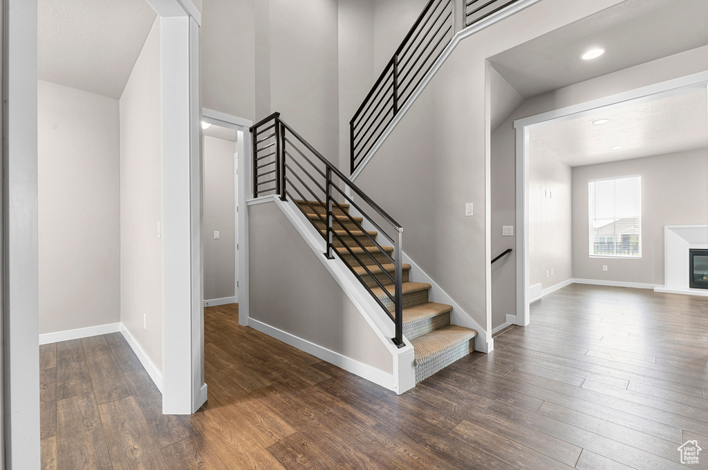Staircase featuring wood finished floors and recessed lighting