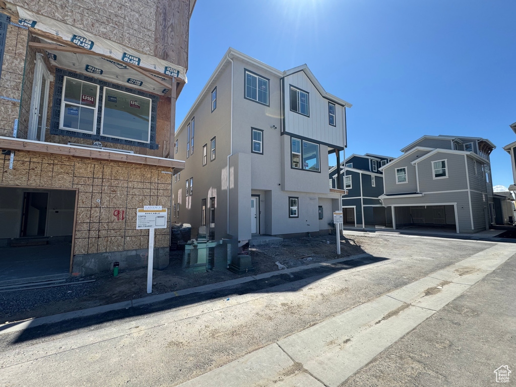 View of front of property featuring an attached garage and stucco siding