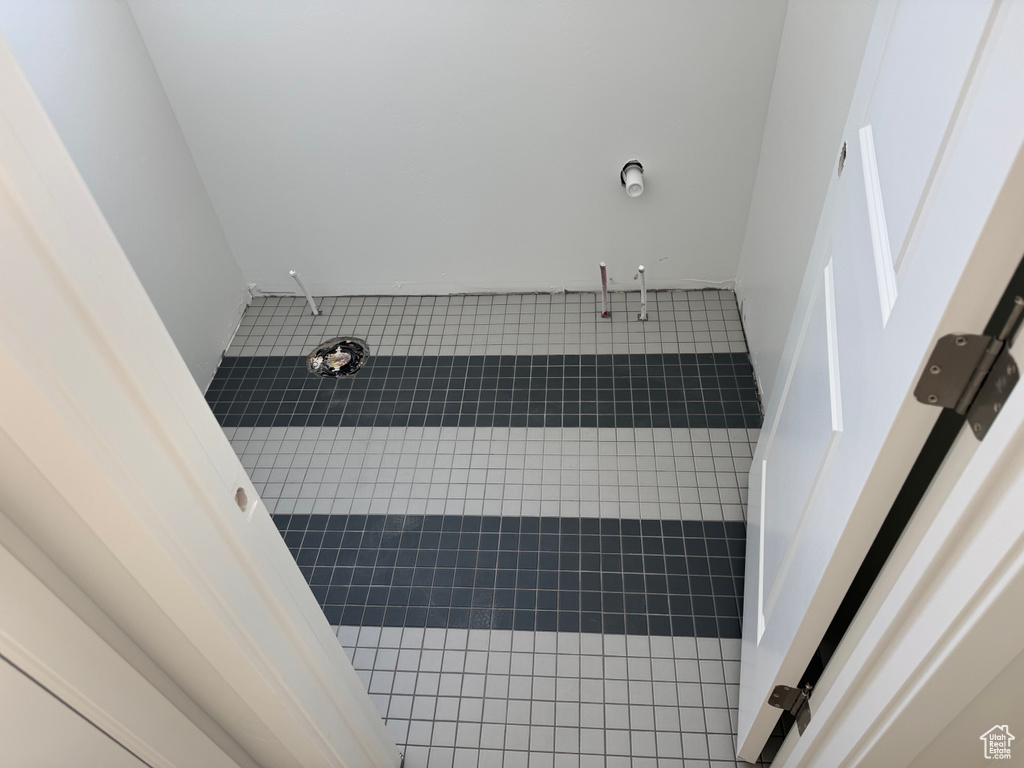 Full bath featuring tiled shower and tile patterned floors