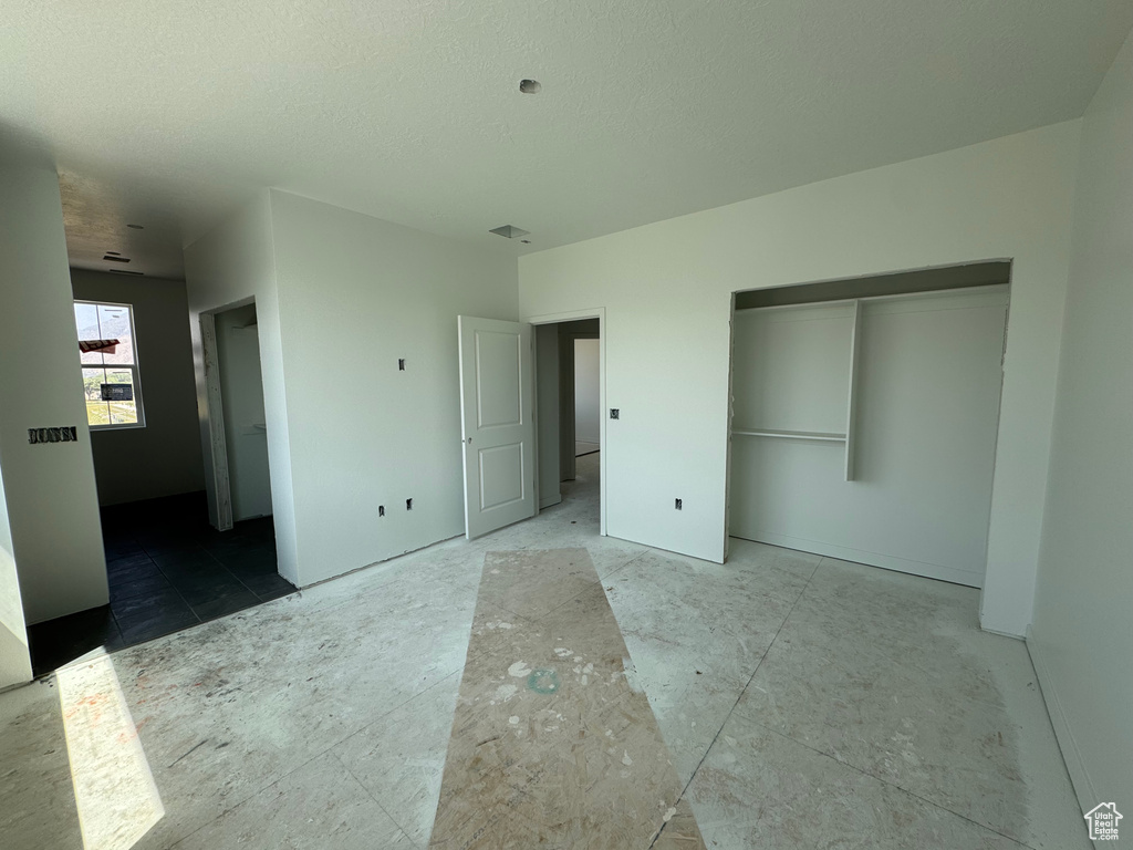 Unfurnished bedroom with a closet and a textured ceiling