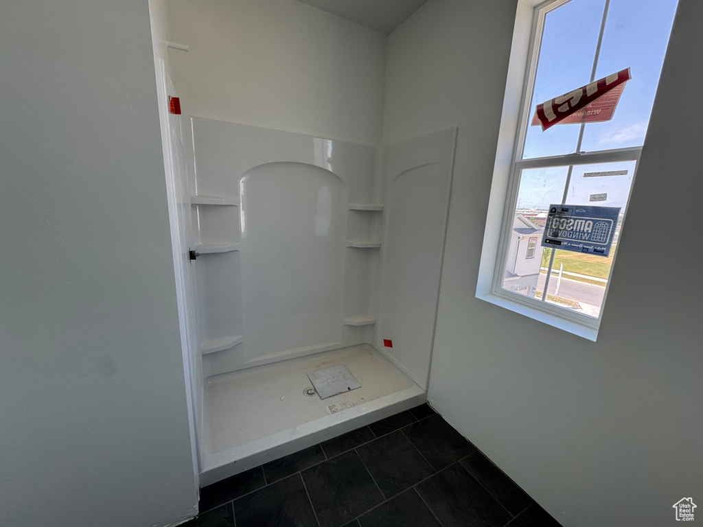 Full bathroom featuring a stall shower and tile patterned flooring