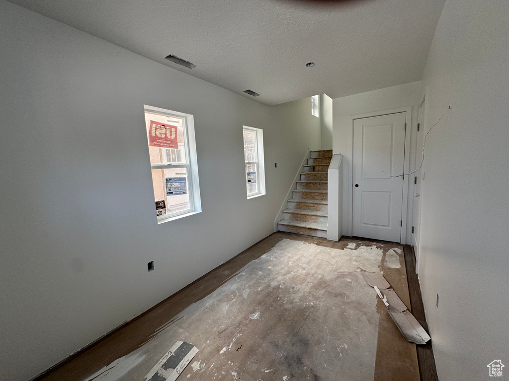 Foyer entrance featuring stairs and a textured ceiling
