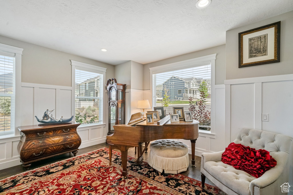 Office area featuring a decorative wall, wood finished floors, wainscoting, a textured ceiling, and recessed lighting