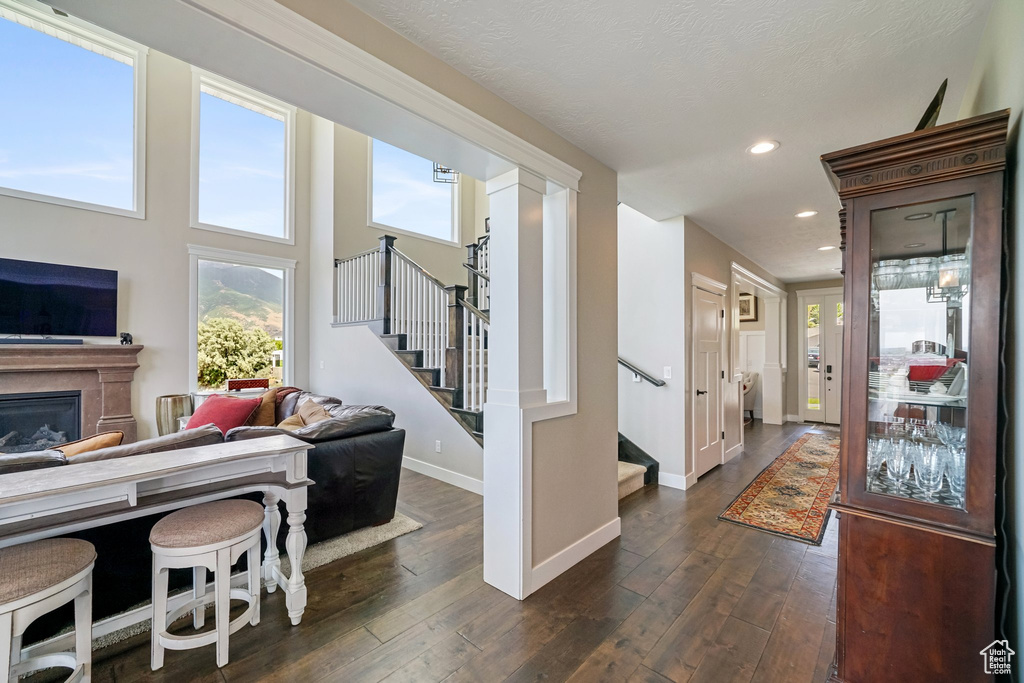 Foyer entrance featuring stairway, dark wood finished floors, recessed lighting, and a glass covered fireplace