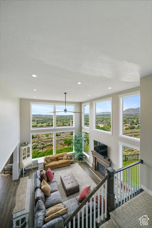 Living room with healthy amount of natural light, wood finished floors, recessed lighting, a textured ceiling, and a ceiling fan