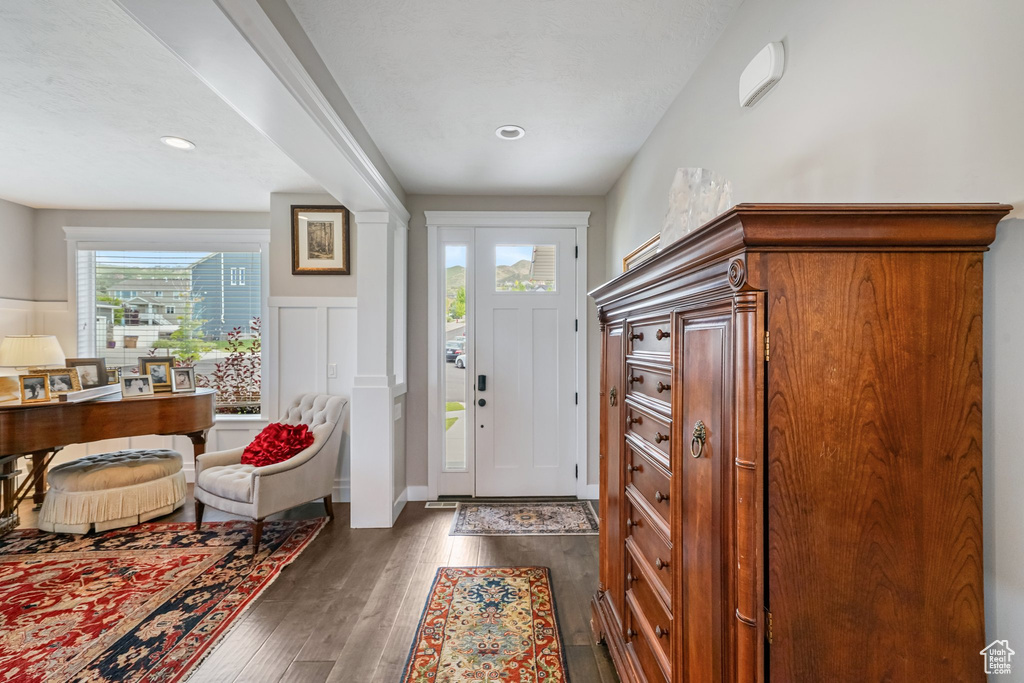Foyer with dark wood finished floors and recessed lighting