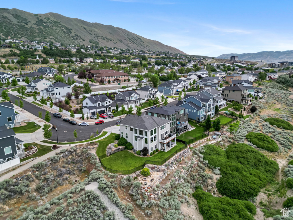 Aerial view of property and surrounding area with a mountain backdrop and nearby suburban area