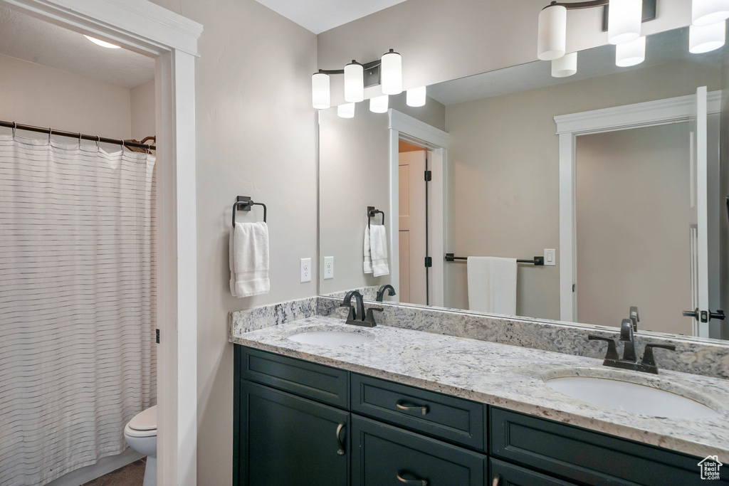 Bathroom featuring double vanity and a shower with shower curtain