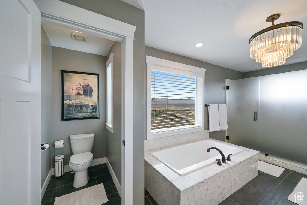 Full bath featuring a bath, tile patterned floors, a shower stall, and a chandelier