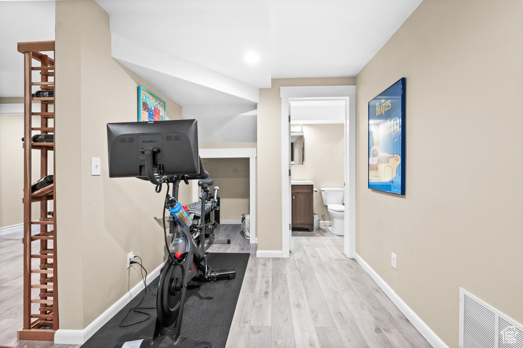 Exercise area with wood finished floors and baseboards