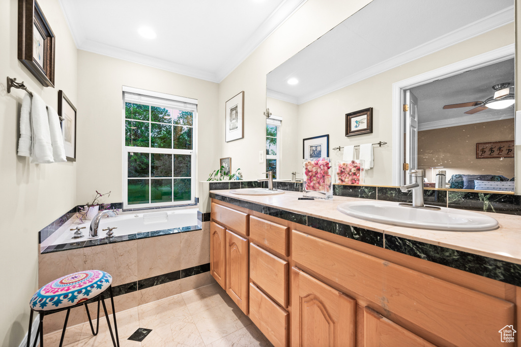 Full bathroom with double vanity, crown molding, a garden tub, and recessed lighting