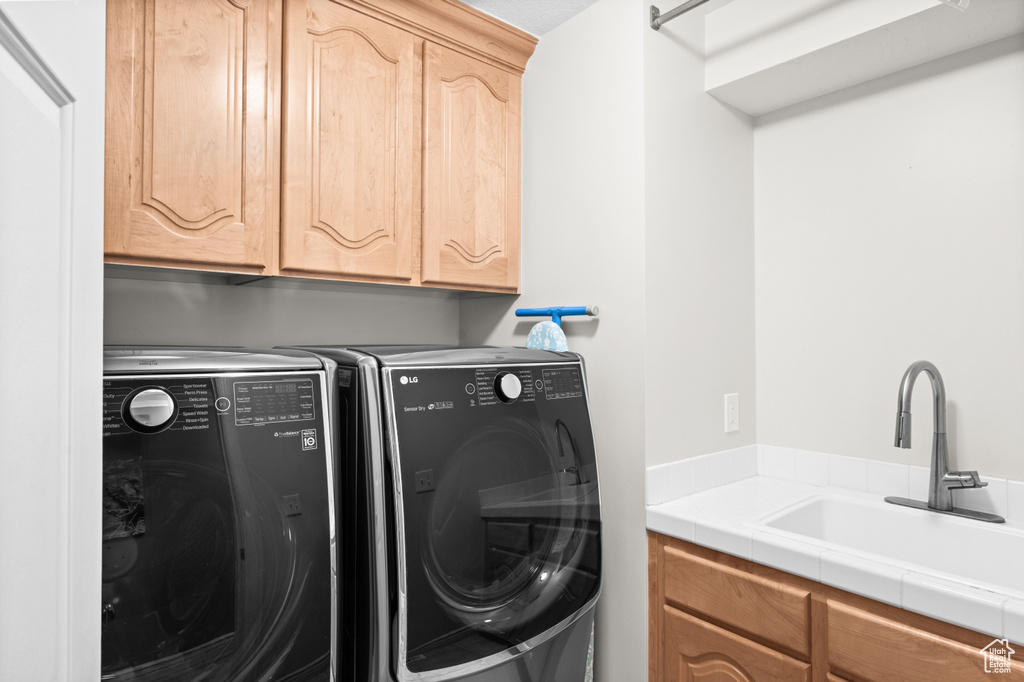 Laundry room with cabinet space and washer and clothes dryer