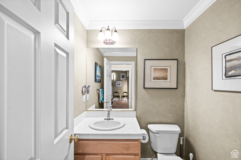 Half bathroom featuring crown molding and vanity