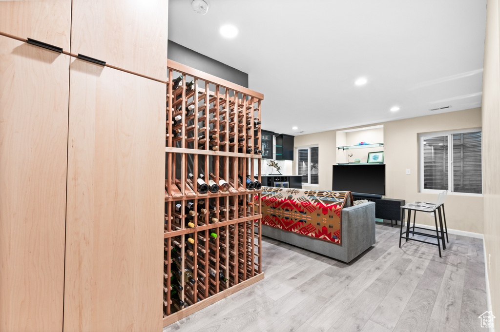 Wine room featuring wood finished floors and recessed lighting