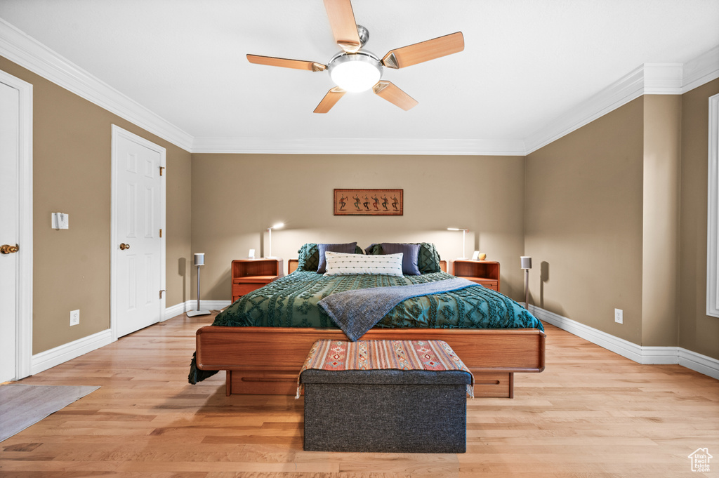Bedroom featuring crown molding, light wood finished floors, and a ceiling fan