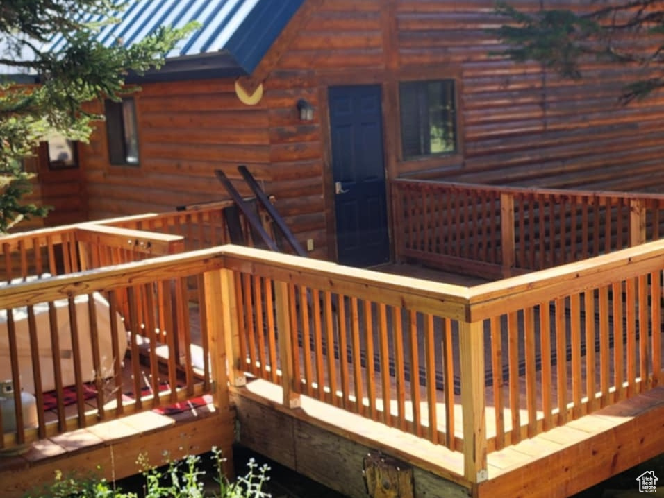 Back of house featuring a standing seam roof, a deck, and a metal roof