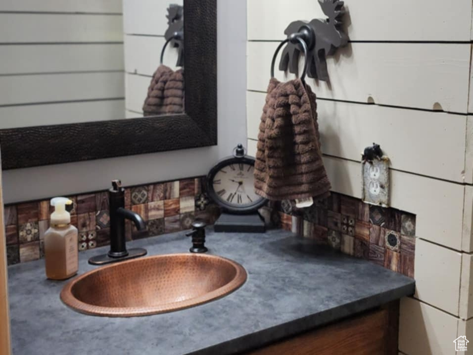 Bathroom featuring vanity and wood walls