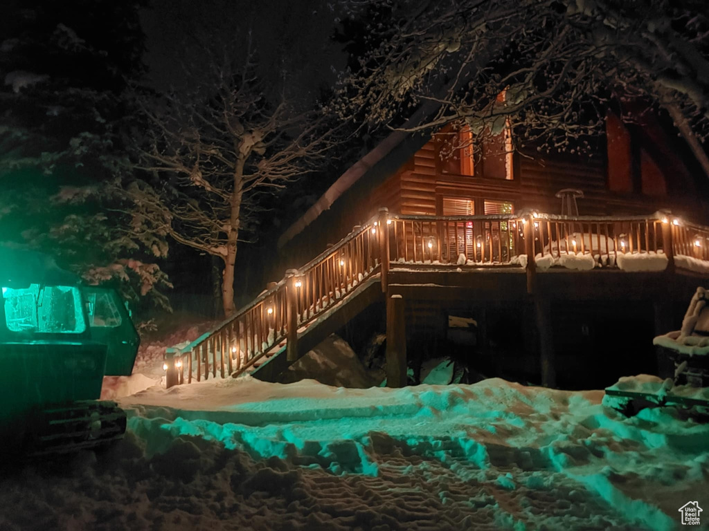 Back of house at twilight featuring stairs and a deck