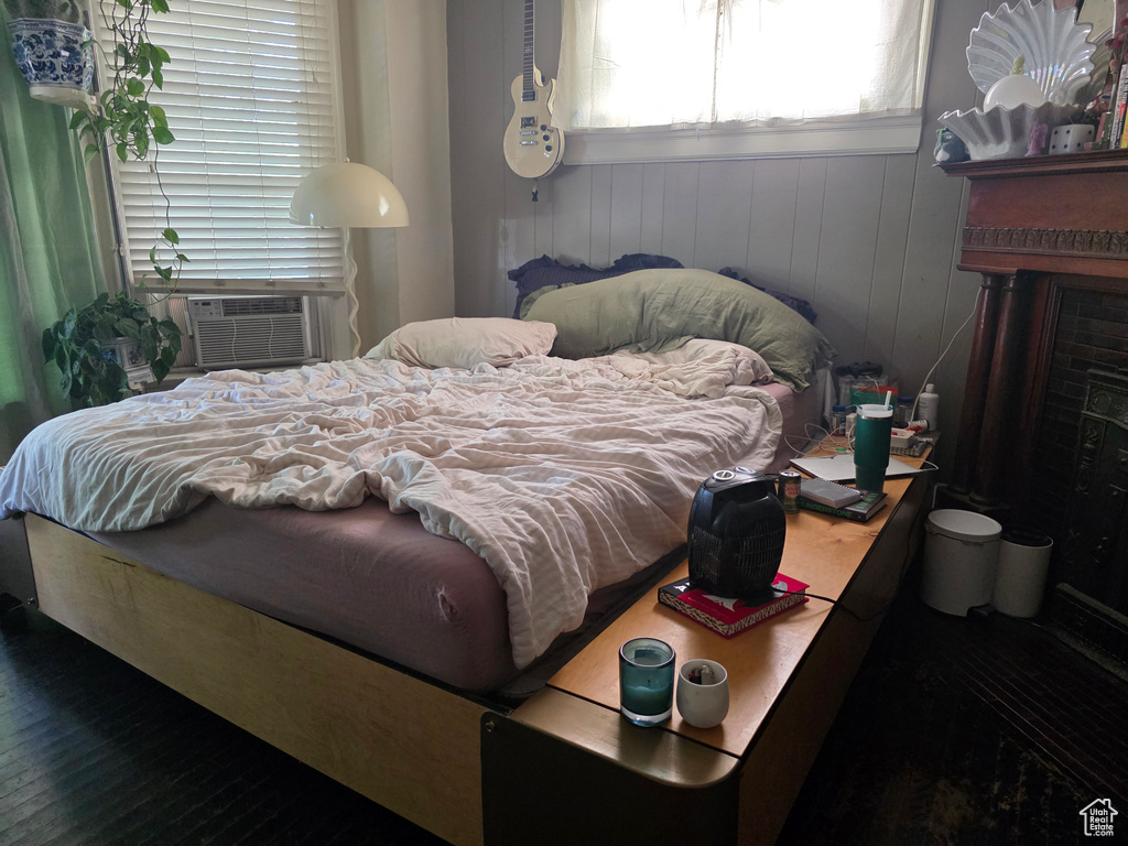 Bedroom featuring a fireplace, wood finished floors, and cooling unit
