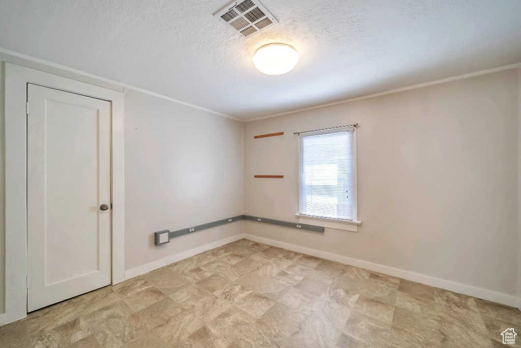 Unfurnished room featuring a textured ceiling and baseboards