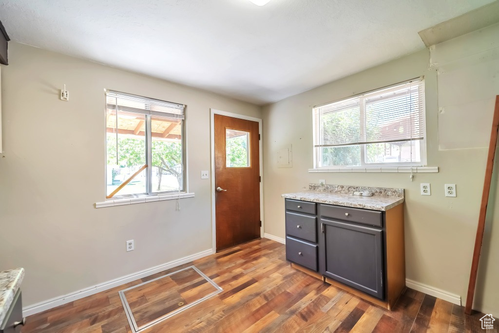 Kitchen with gray cabinets, healthy amount of natural light, and dark wood-style floors