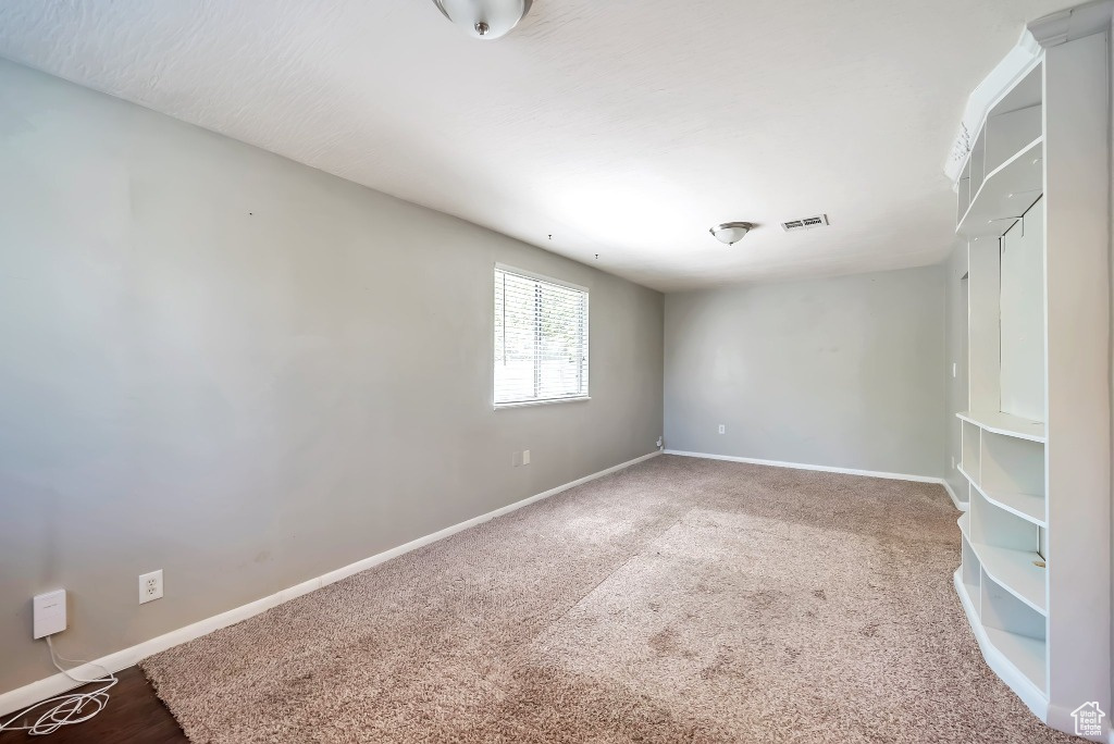 Carpeted spare room featuring baseboards