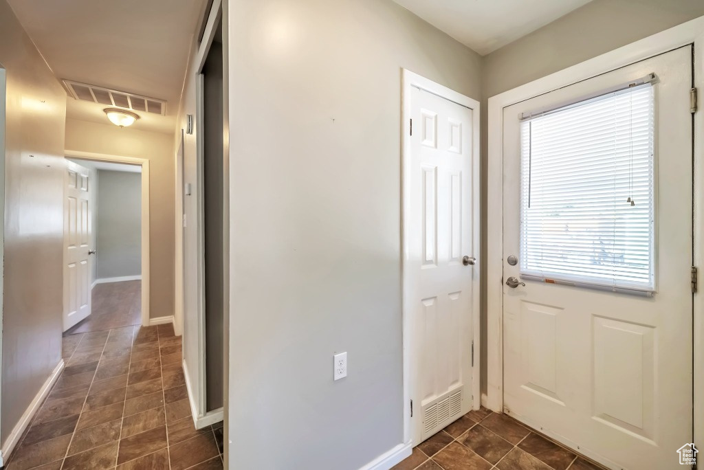 Doorway with healthy amount of natural light and stone finish flooring