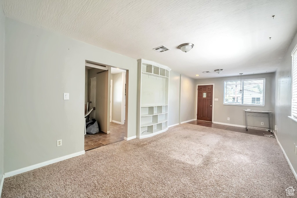 Unfurnished room featuring carpet flooring and built in shelves