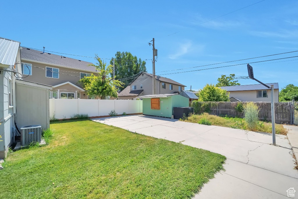 Fenced backyard with a patio area and an outbuilding