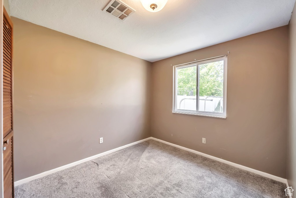 Carpeted empty room with baseboards