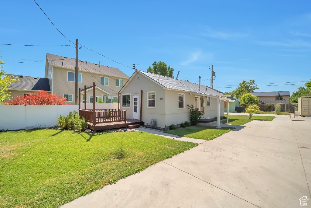 Rear view of house featuring a wooden deck and driveway