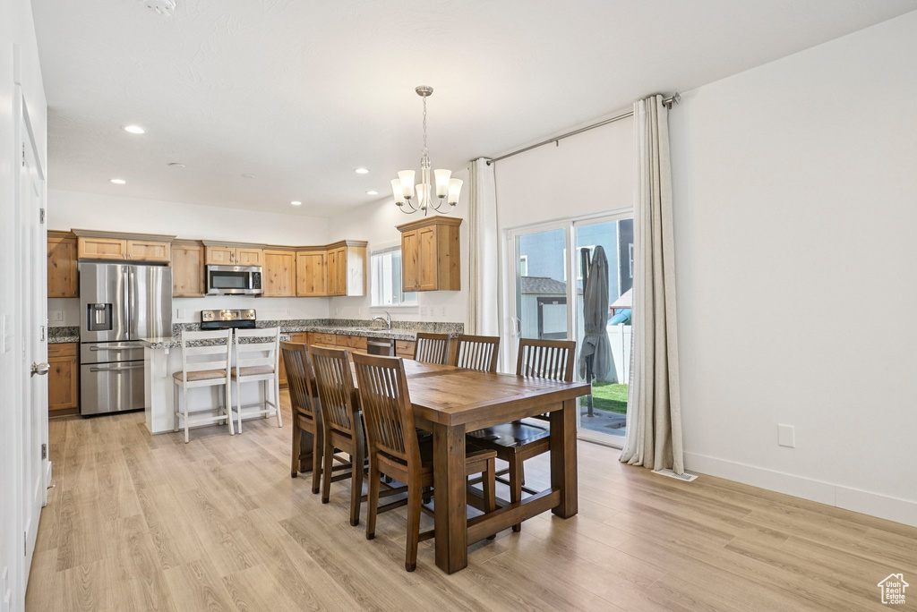 Dining area with a chandelier, light wood-style flooring, recessed lighting, and baseboards
