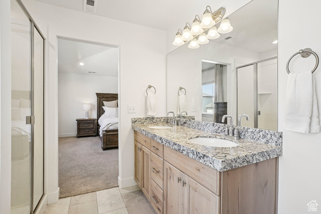 Full bath with double vanity, ensuite bath, a stall shower, baseboards, and recessed lighting