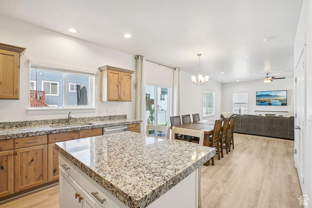 Kitchen with a sink, a chandelier, light wood-style floors, a center island, and open floor plan