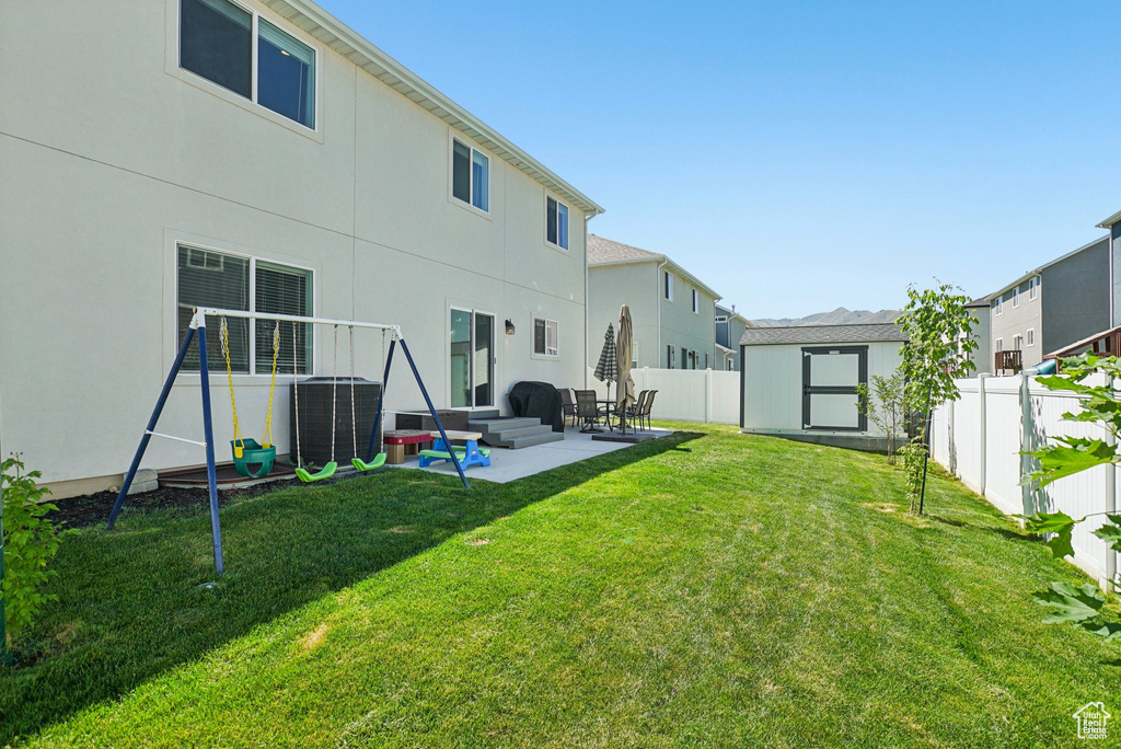 Back of property featuring a patio area, central AC unit, stucco siding, and a residential view