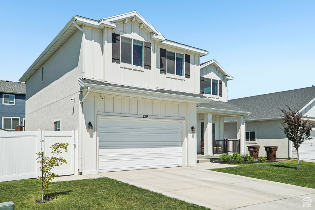 View of front of home featuring board and batten siding, a garage, driveway, and a porch
