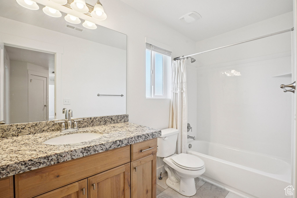 Full bath with shower / bath combo, vanity, toilet, and tile patterned flooring
