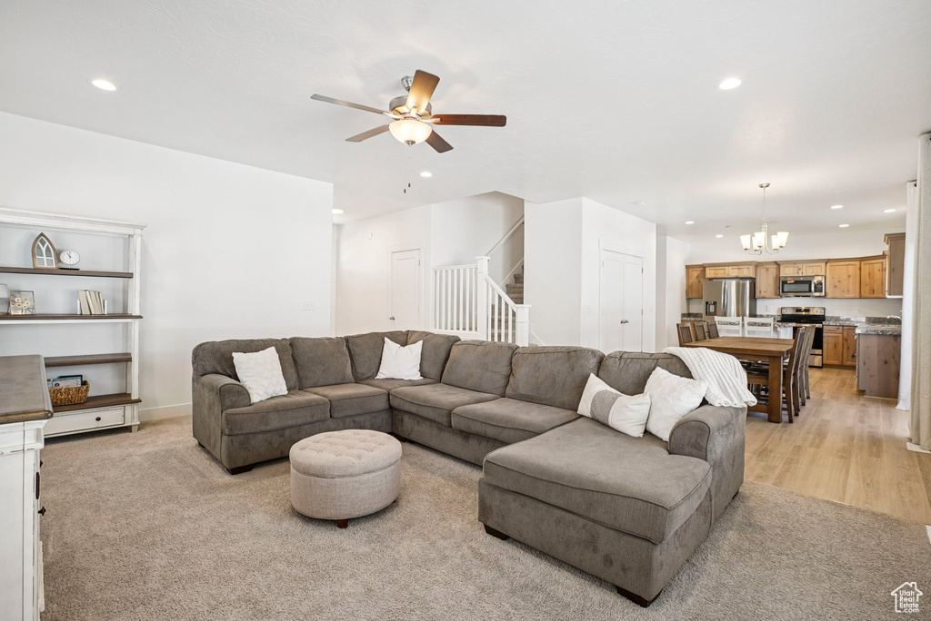 Living area with a chandelier, recessed lighting, stairs, and a ceiling fan