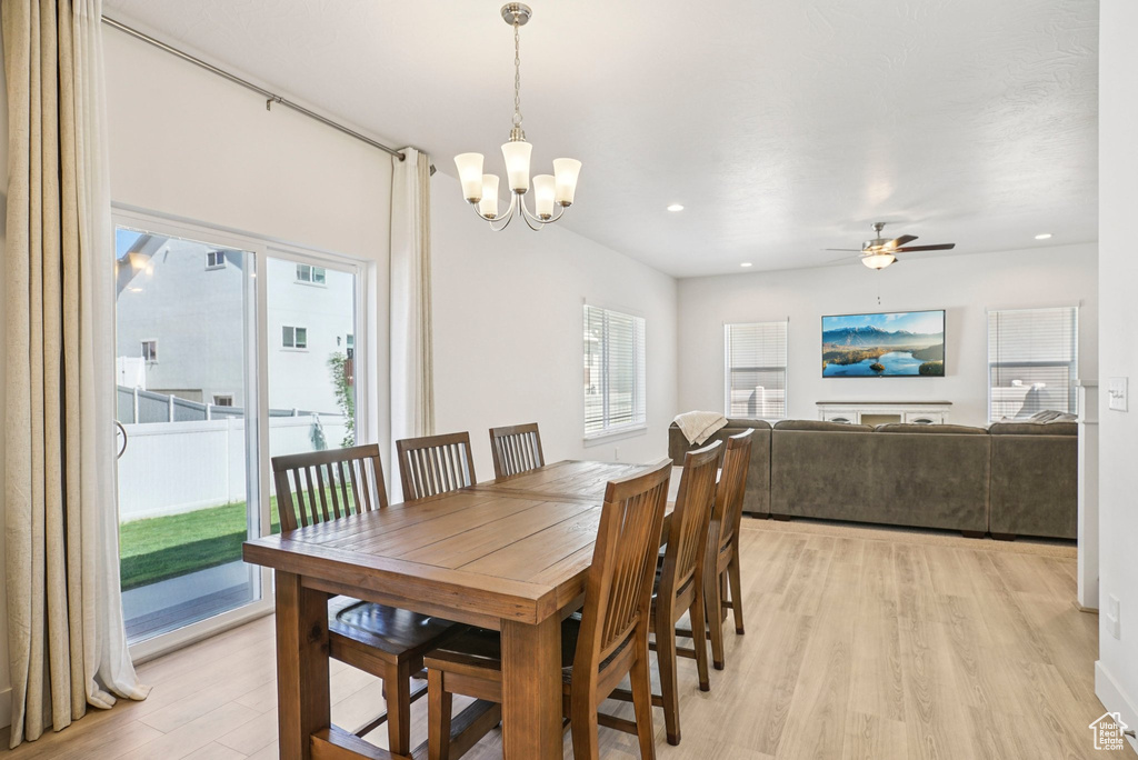 Dining area with light wood-style flooring, a chandelier, a ceiling fan, and recessed lighting