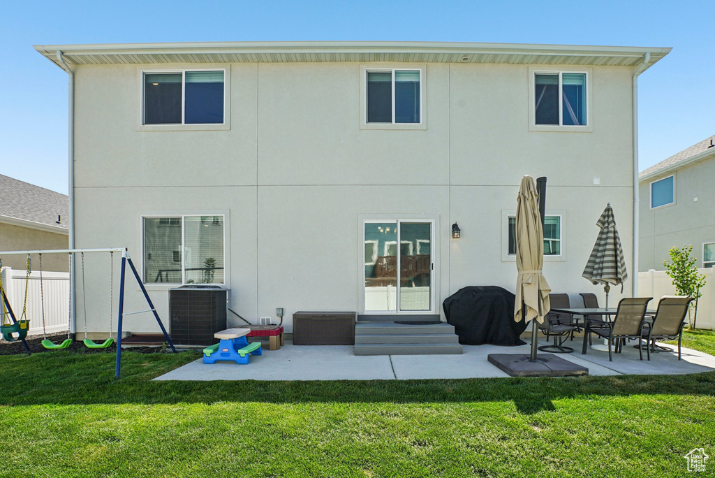 Rear view of house featuring cooling unit, a patio, and stucco siding