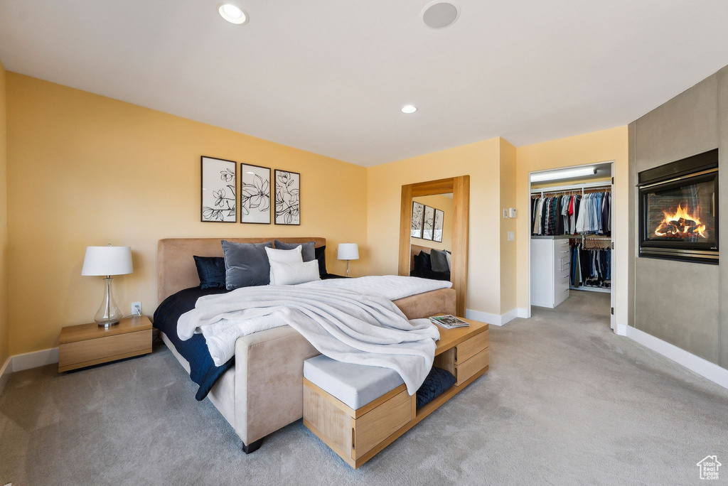 Bedroom featuring light colored carpet, recessed lighting, and a closet