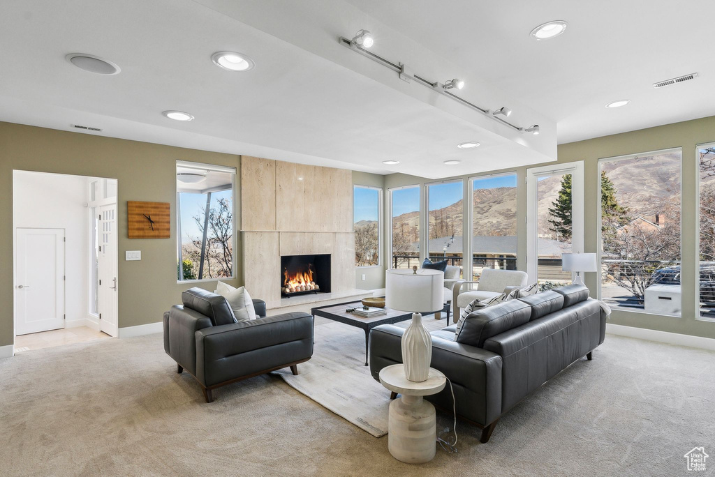 Living room with light carpet, a large fireplace, recessed lighting, and a mountain view