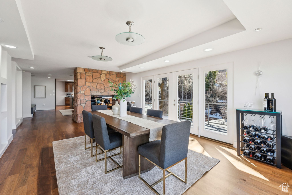 Dining area featuring recessed lighting, wood finished floors, french doors, and a stone fireplace