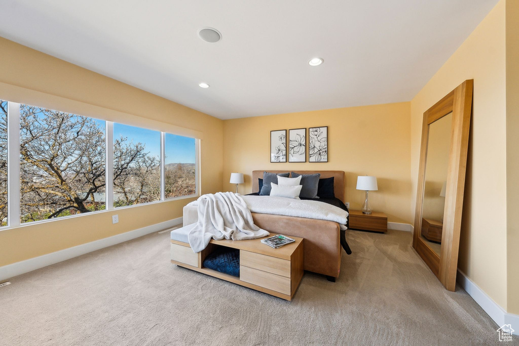 Bedroom with light colored carpet and recessed lighting