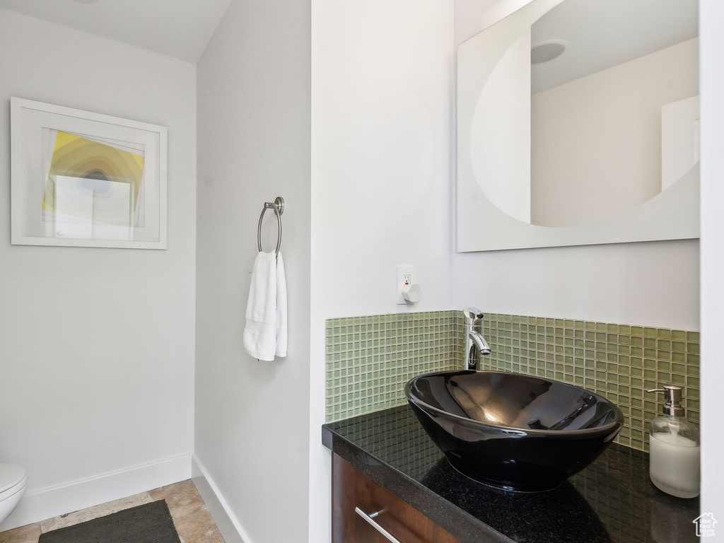 Bathroom featuring vanity and backsplash