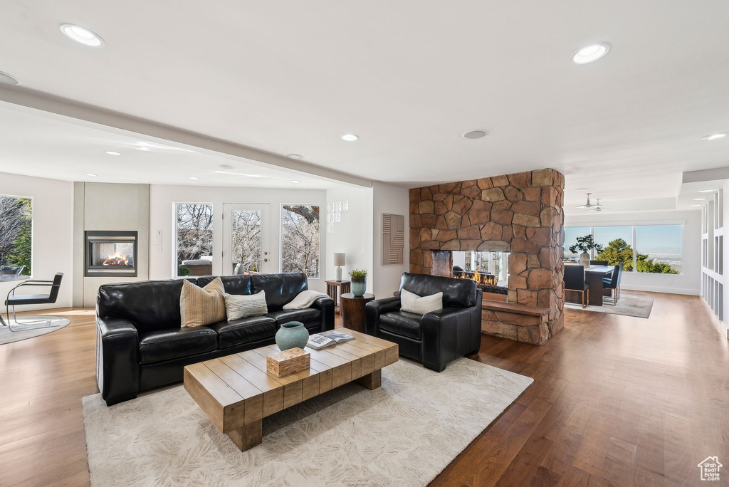 Living area featuring a multi sided fireplace, wood finished floors, and recessed lighting