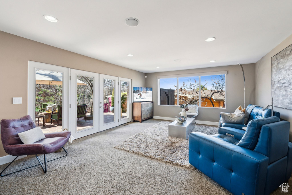 Carpeted living room with plenty of natural light and recessed lighting