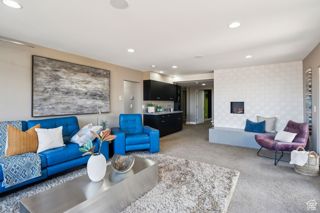 Living room featuring light colored carpet, recessed lighting, and a tiled fireplace