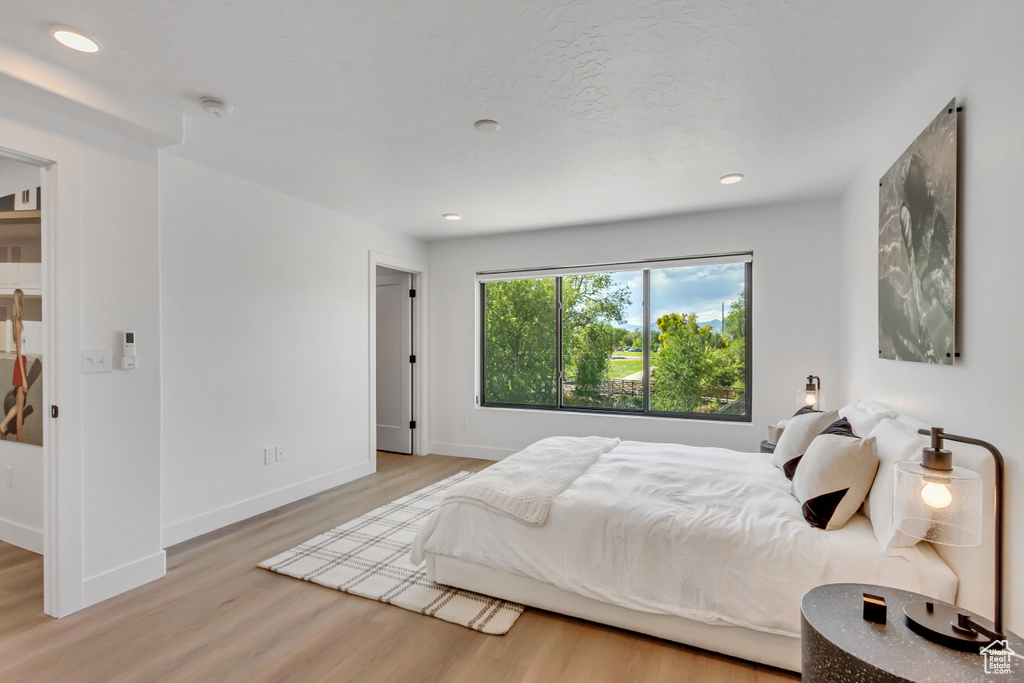 Bedroom with wood finished floors and recessed lighting